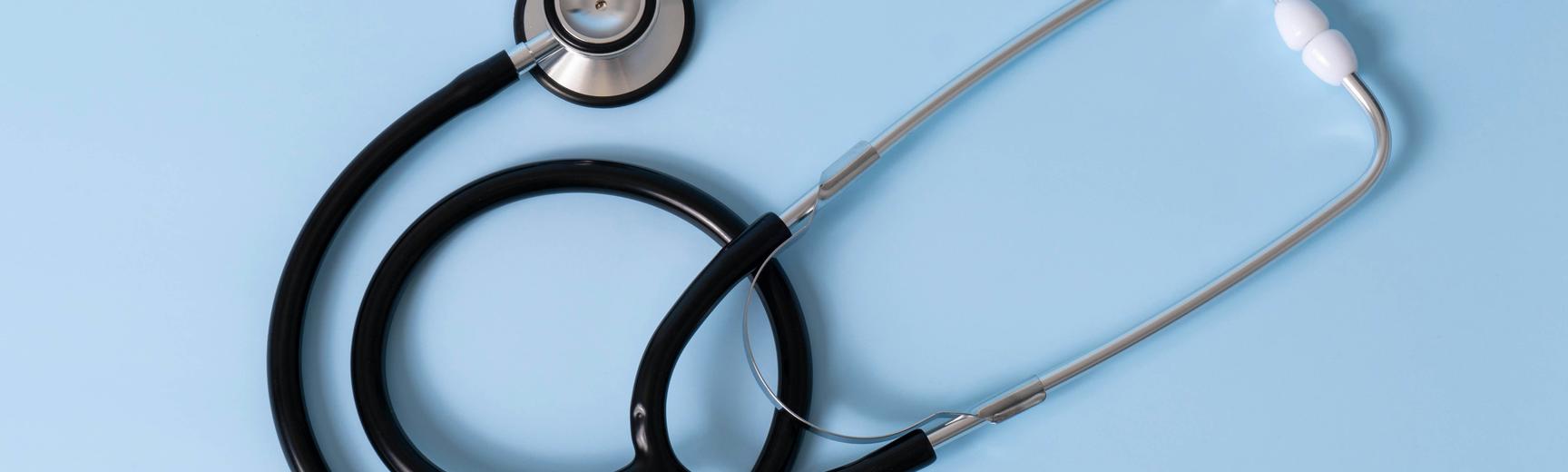 A stethoscope lying on a blue background
