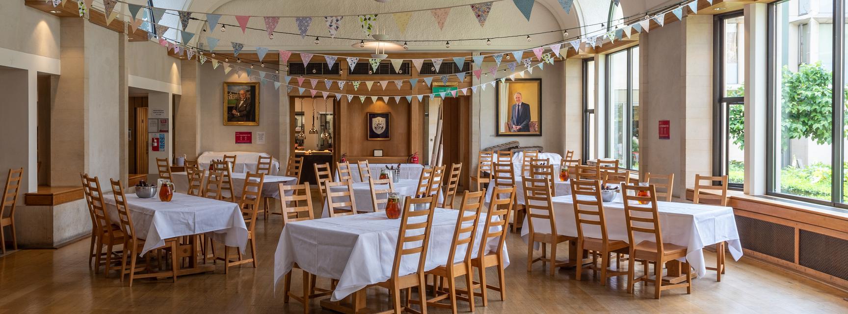 St Cross hall with bunting and tables arranged for intimate event
