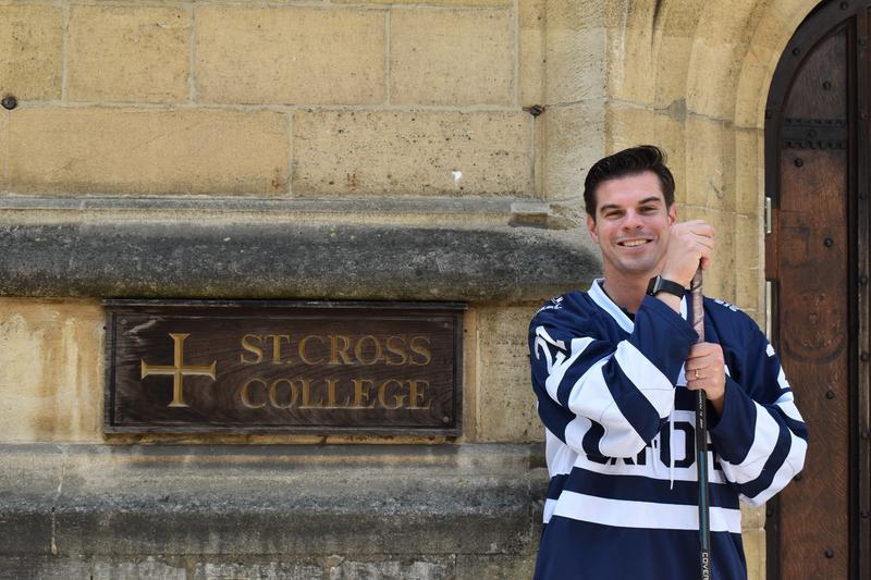 Jake Schneider stands in front of the St Cross College front door in his Blues Jersey