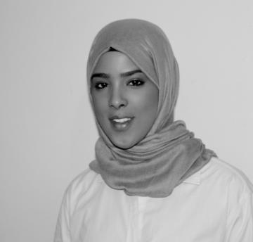 Yasmin Ahmed black and white shot, wearing headscarf and shirt.