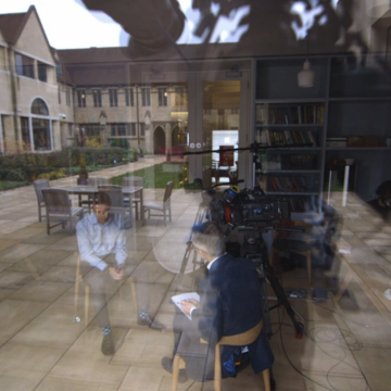 filming in the library with a reflection of the quad