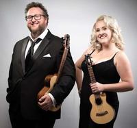 male and female both stood smiling with ukuleles wearing formal evening wear.